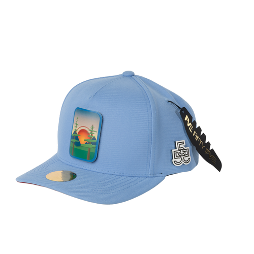 Beyond The Pines blue A-frame snapback hat side view with forest sunset badge and FveFiftyFve logo